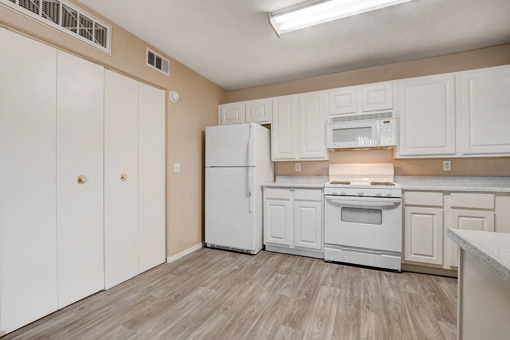 A kitchen with white appliances and cabinets.