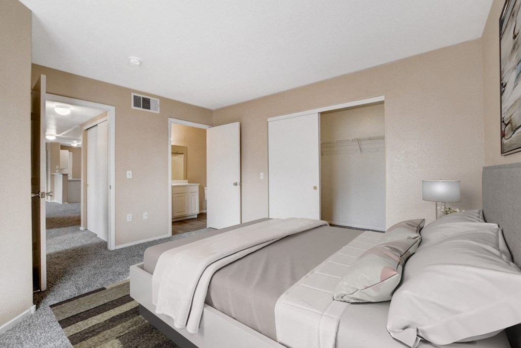 A bedroom with a large bed and a carpeted floor.