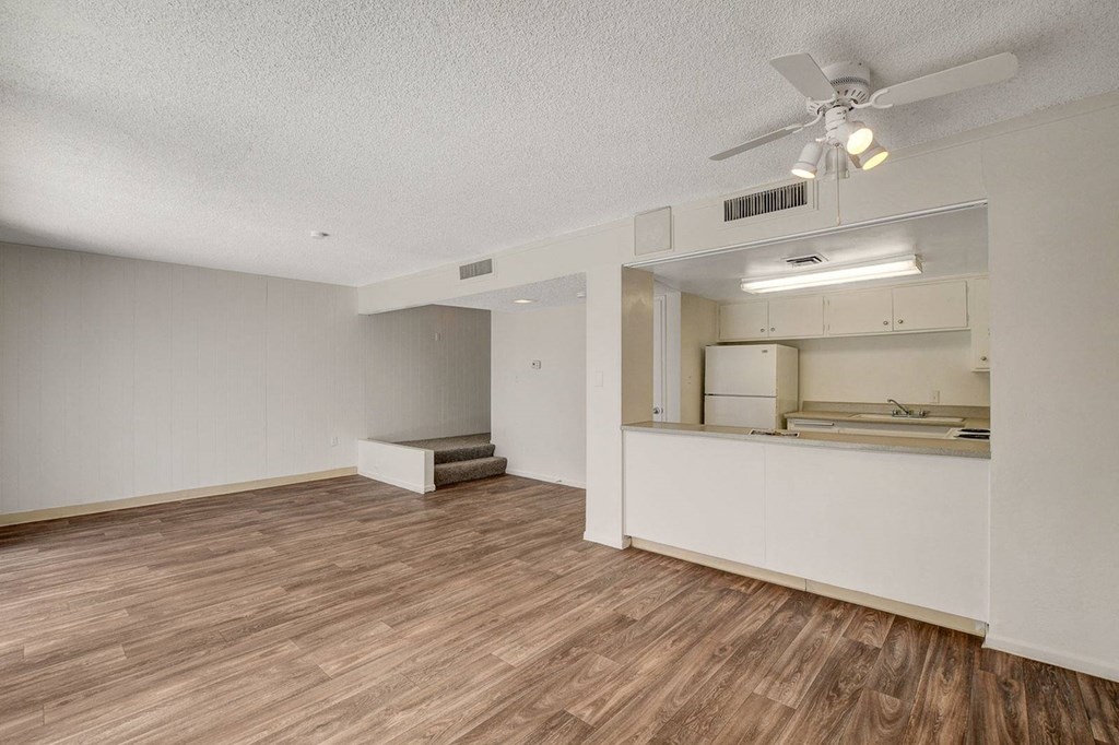 A room with a ceiling fan and wooden flooring.