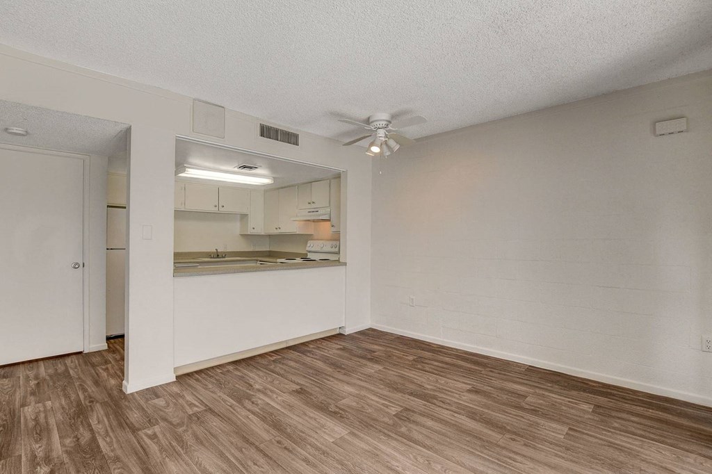 A room with a ceiling fan and a mirrored cabinet.