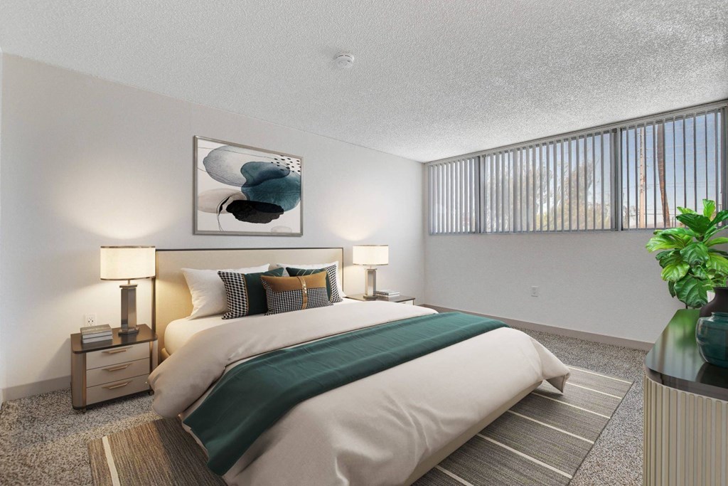 A bedroom with a large bed and a painting on the wall.