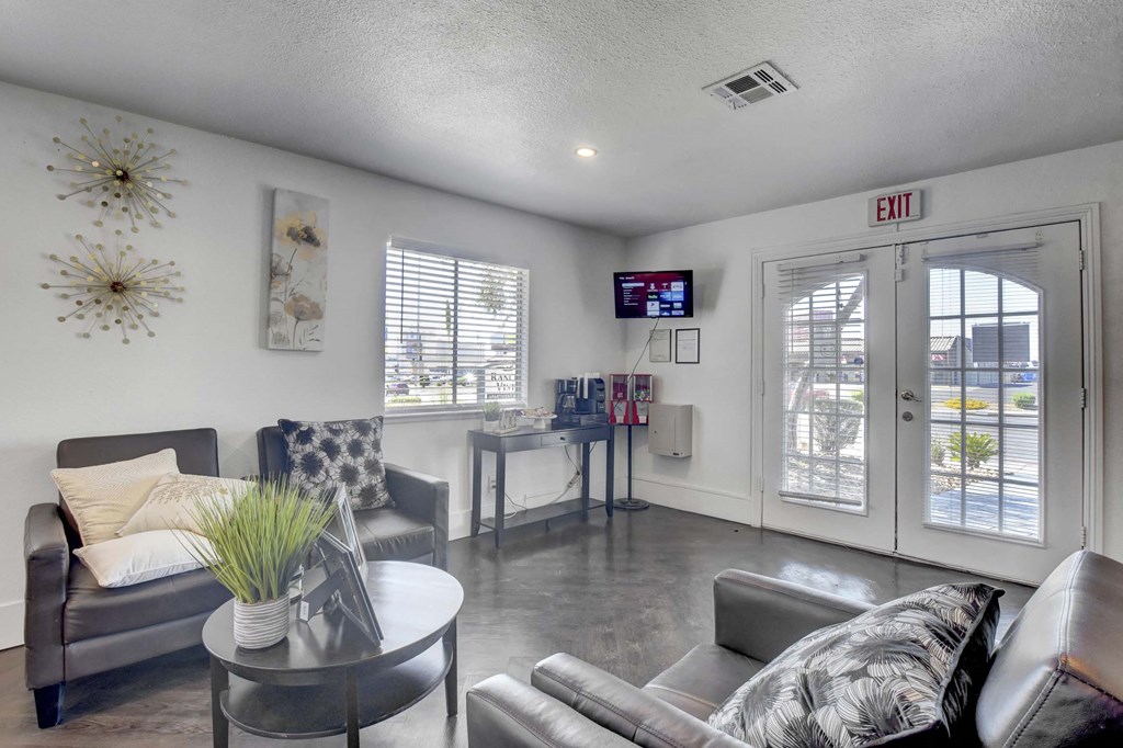 A living room with a grey couch, a coffee table, and a TV screen.