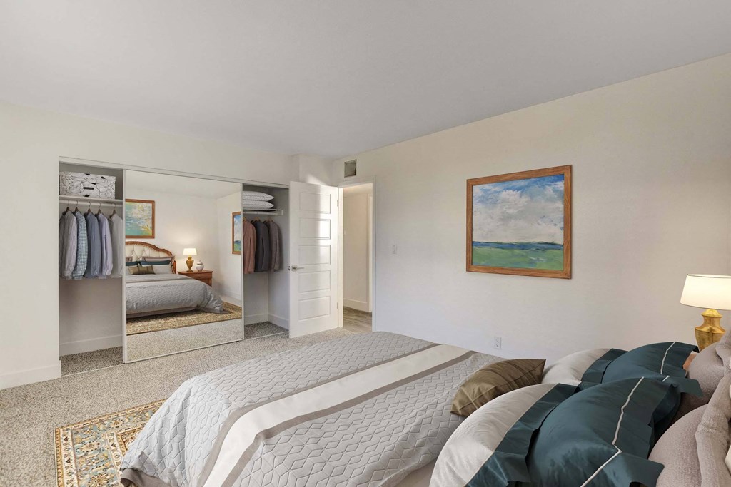 A bedroom with a large bed and a painting on the wall.