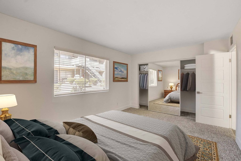 A bedroom with a large bed and a painting on the wall.