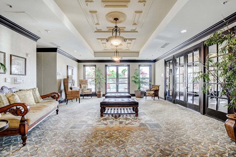 A large, well-furnished living room with a patterned carpet and a chandelier.