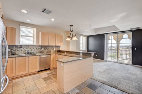 A kitchen with wooden cabinets and a checkered floor.