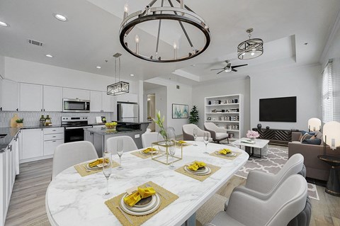 A modern dining room with a marble table set for a meal.
