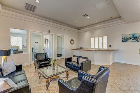 A living room with a glass table and leather chairs.