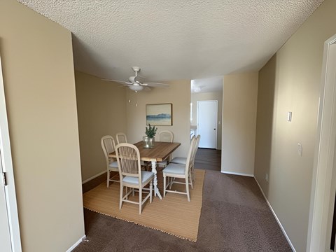 A dining room with a table and chairs.