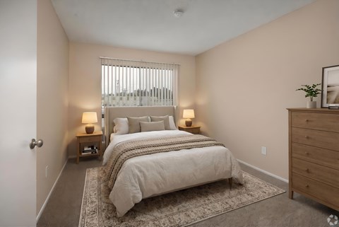 A bedroom with a large bed and two lamps.