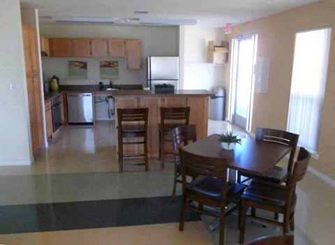 A kitchen with a table and chairs in the middle of the room.