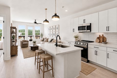 A modern kitchen with white cabinets and a large island.