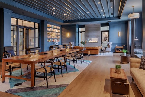 A modern dining room with a long wooden table and chairs.