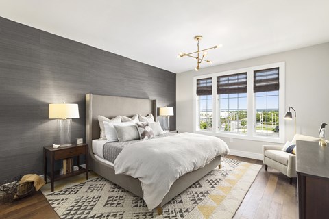 A bedroom with a large bed and a window with blinds.