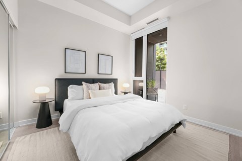 A bedroom with a large bed and two nightstands with lamps.