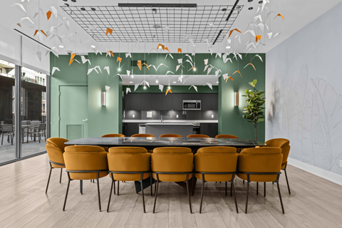 A dining room with a table surrounded by chairs.