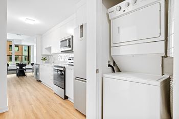 A white kitchen with a refrigerator, oven, and microwave.
