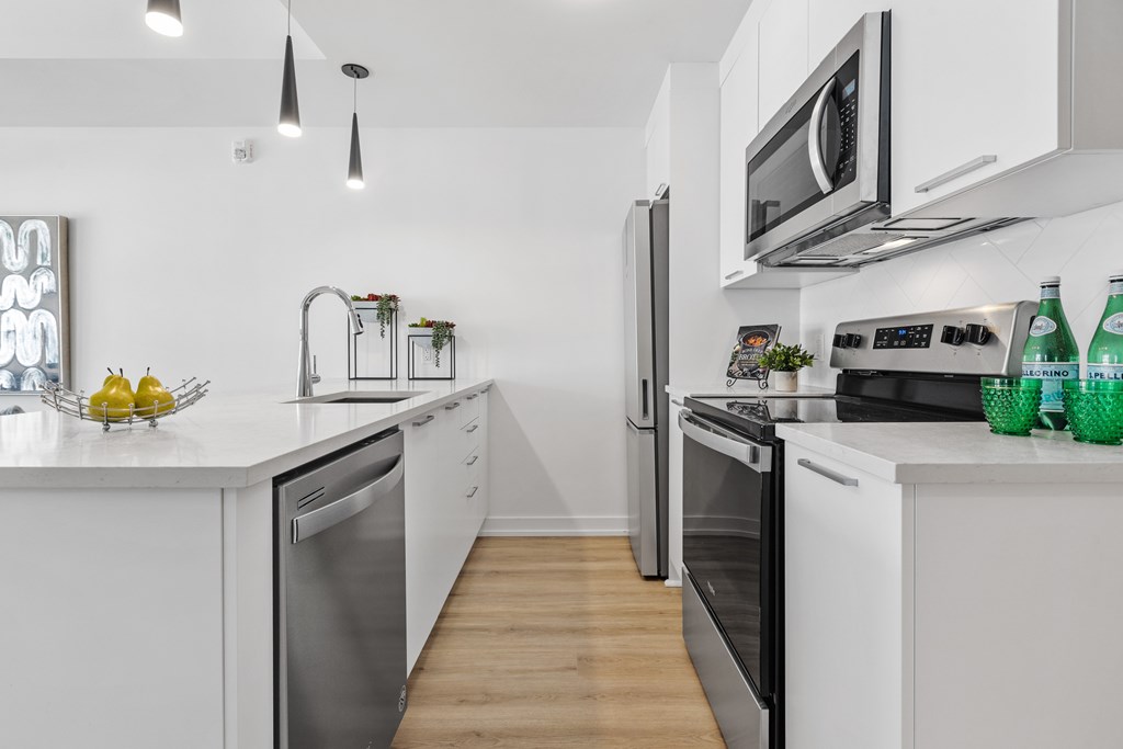 A modern kitchen with white cabinets and stainless steel appliances.