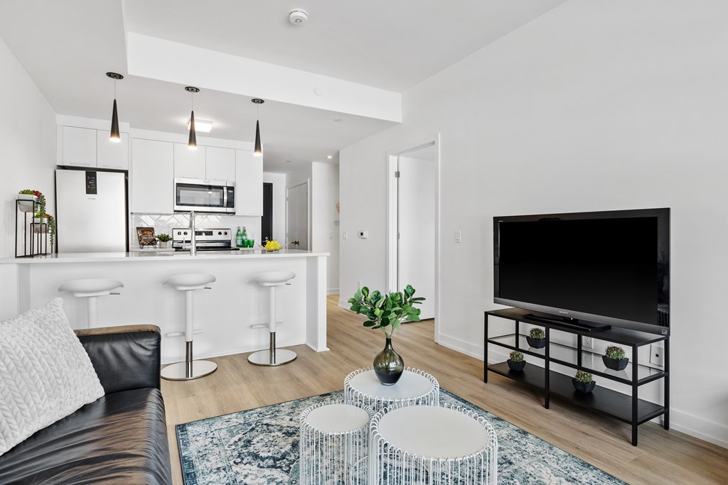 A modern living room with a bar area and a kitchen in the background.