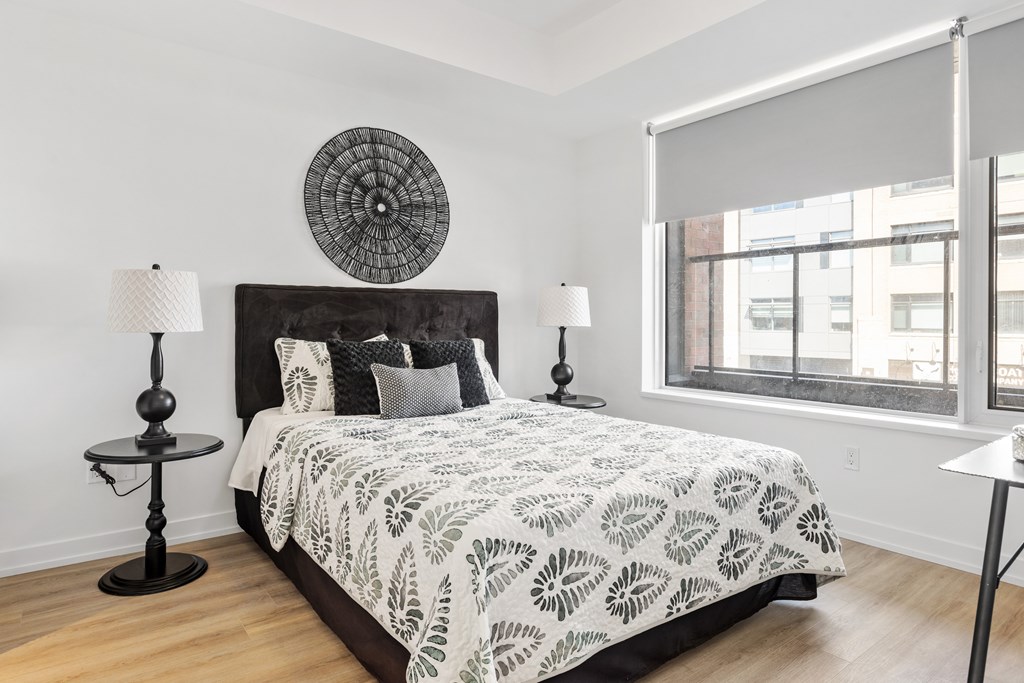 A bedroom with a large bed and a round decorative piece on the wall.