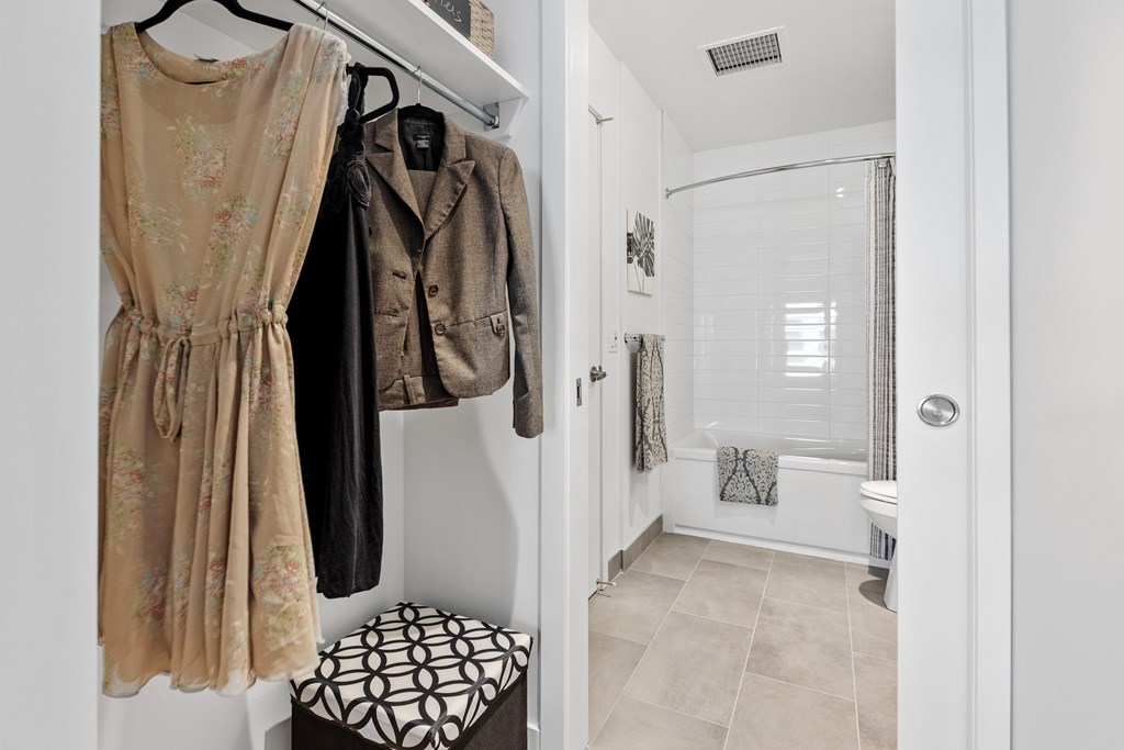 A bathroom with a shower and a clothing rack.