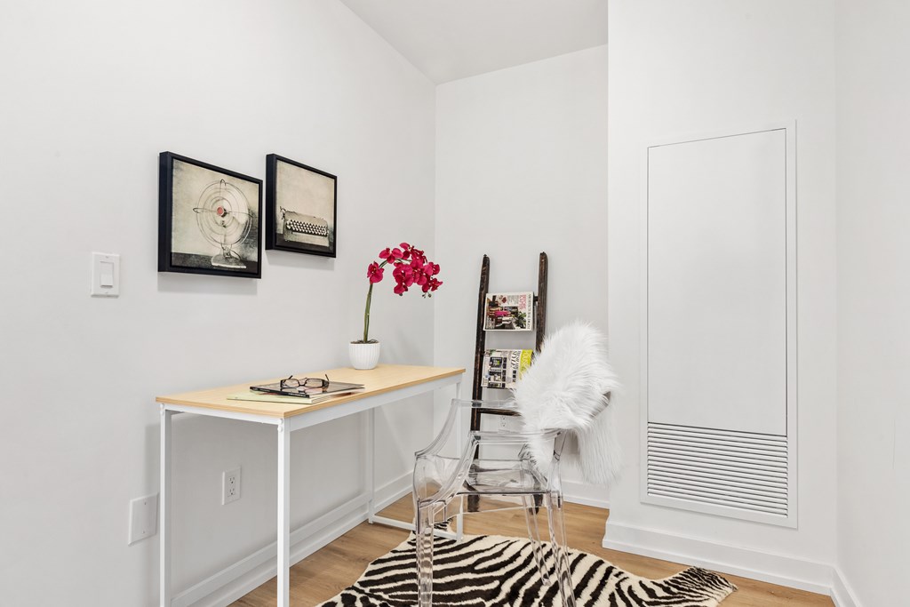 A white chair with a white furry back is in front of a white wall with a white door.