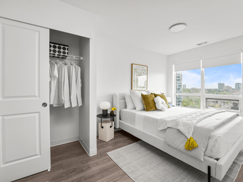A bedroom with a large bed and a view of the city.