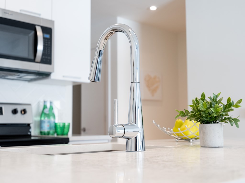 A modern kitchen with a shiny chrome faucet.