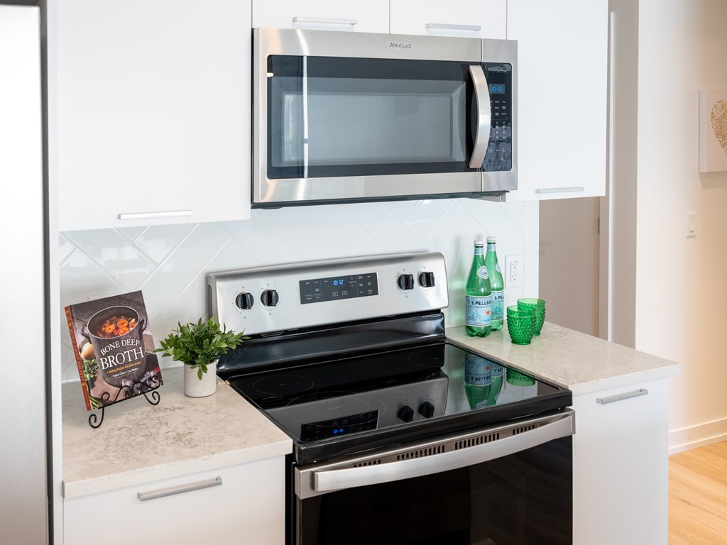 A kitchen with a stove, oven, and microwave.