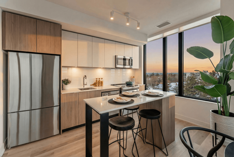 A modern kitchen with a dining table set for two.