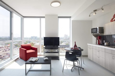 A modern living room with a red chair and a black table.