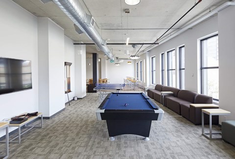 A room with a pool table and a television.