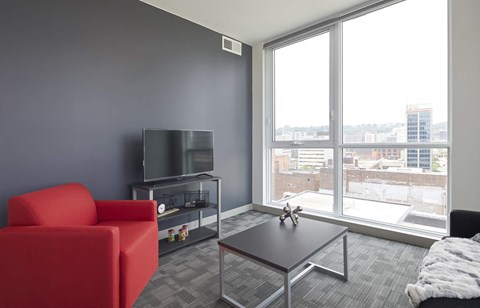 A living room with a red chair, a television, and a coffee table.