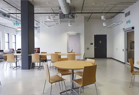 A conference room with a round table and chairs.
