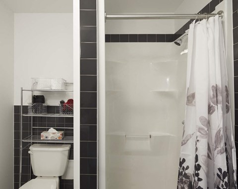 A white toilet sits next to a white bathtub in a bathroom.
