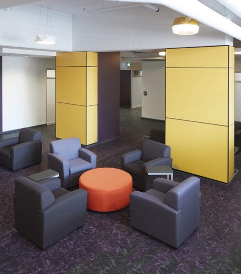 A room with purple carpet and a yellow and brown cubed wall.
