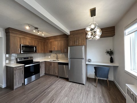 A kitchen with wooden cabinets and a stainless steel refrigerator.