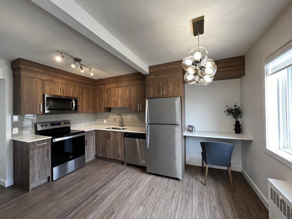 A kitchen with wooden cabinets and a stainless steel refrigerator.