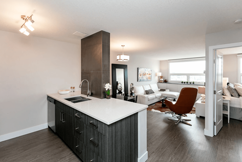 A modern kitchen with a white countertop and a brown chair.