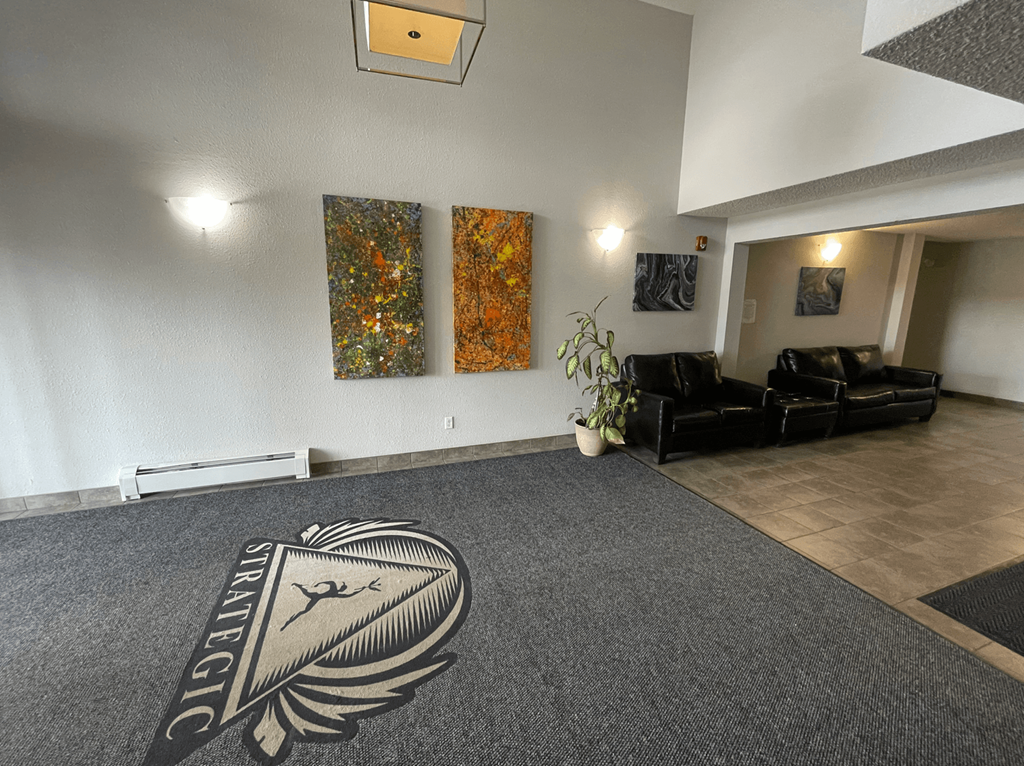 A grey carpet with a logo on it in the middle of a room.