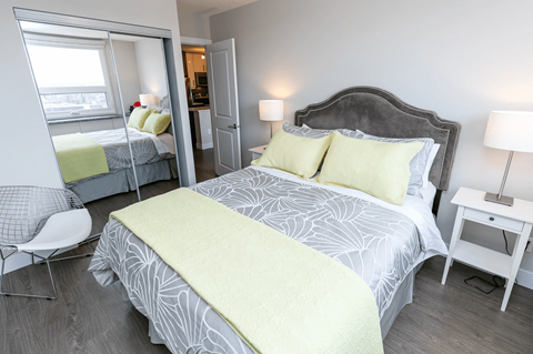 A bedroom with a large bed and a chair.