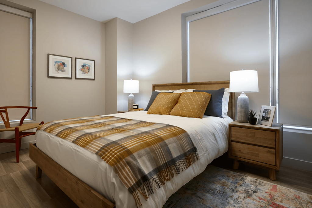 A bedroom with a bed, nightstand, and chair.