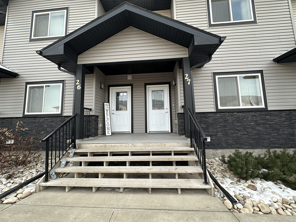 A house with a black front door and a black railing.