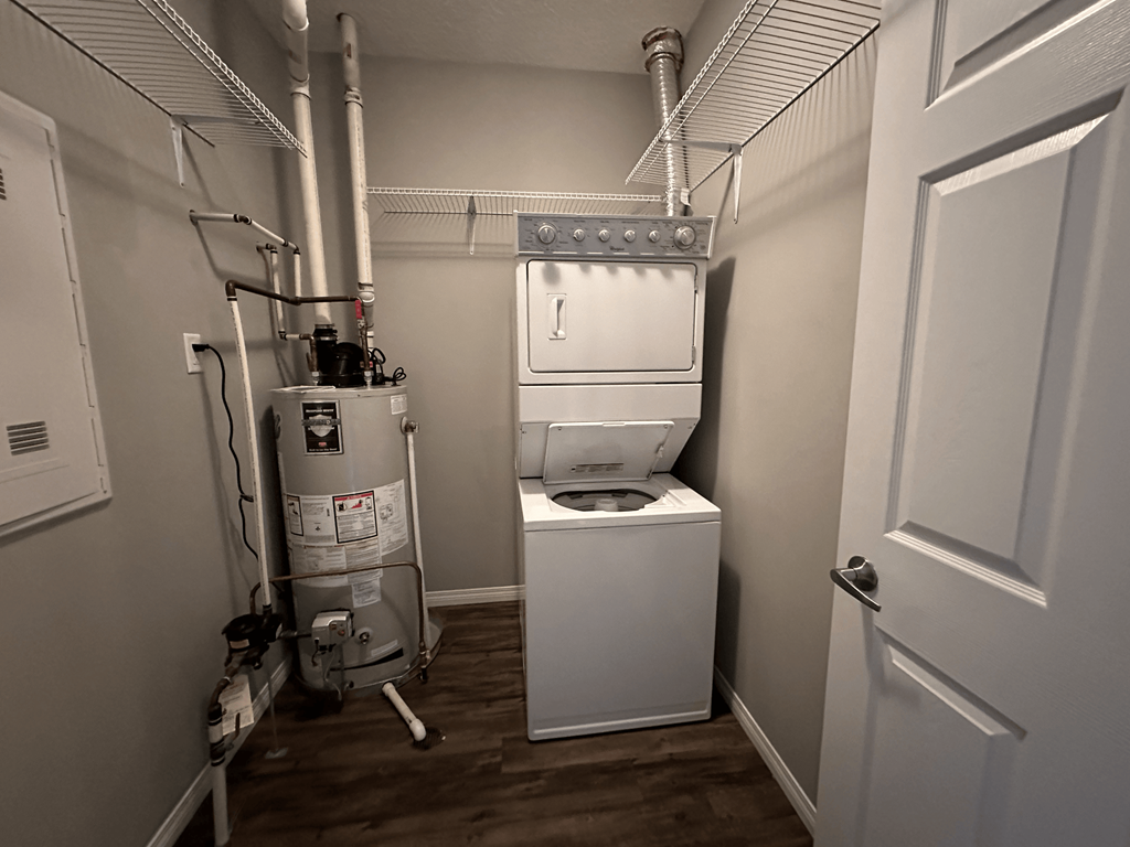 A small, white bathroom with a toilet and a water heater.