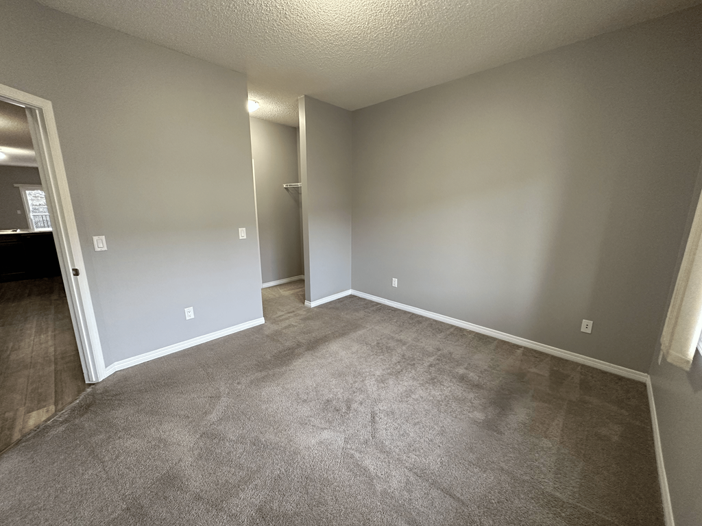 A room with grey carpet and white walls.