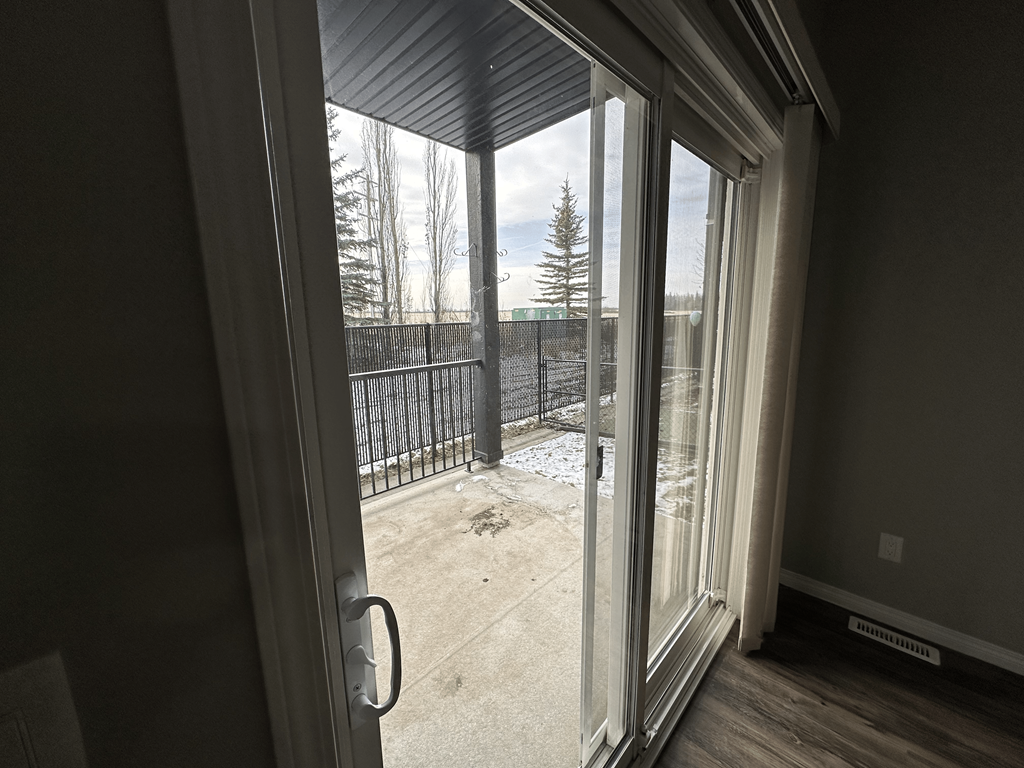 A view from inside a room looking out through a sliding glass door.