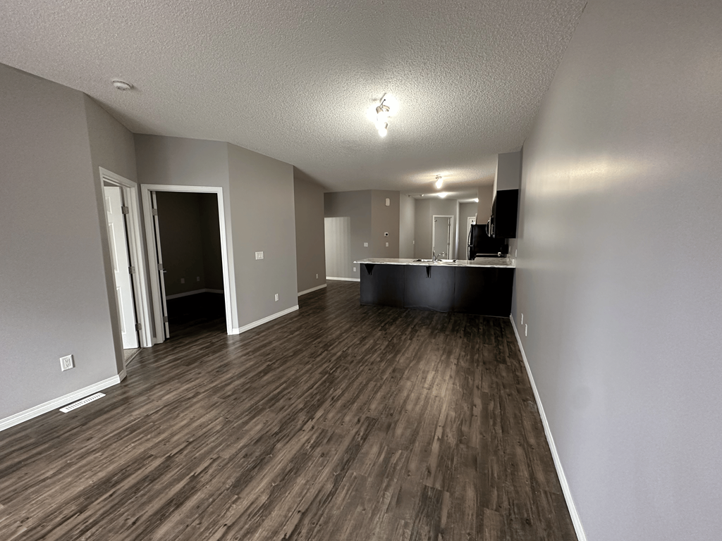 A room with wood flooring and a ceiling light.
