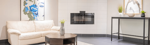 A white couch sits in a living room with a coffee table in front of it.