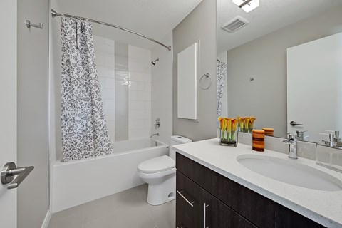 A white toilet sits in a bathroom next to a sink.