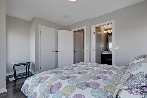 A bedroom with a bed and a table.